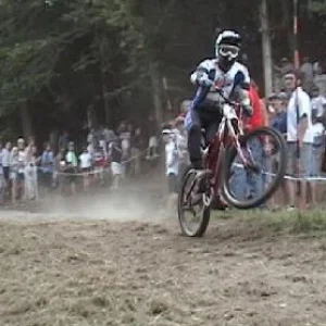 Pro mtn bike racer at the NORBA finals at Mount Snow doing a wheelie with a flat