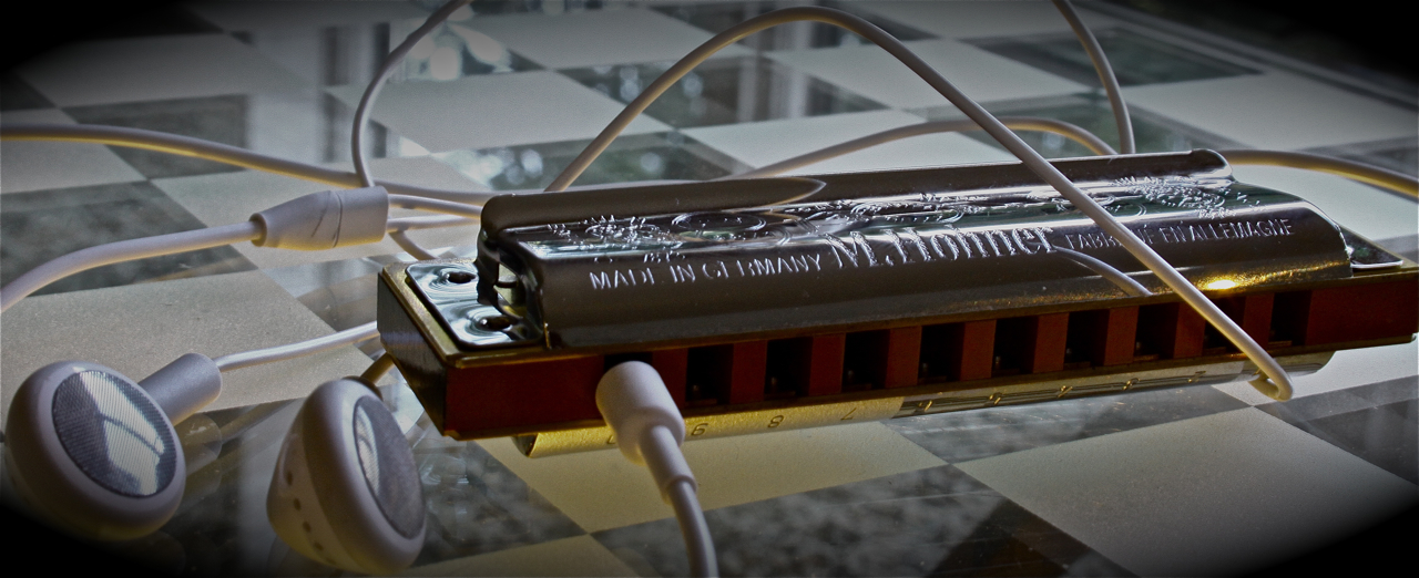 Harmonica with earbuds plugged into it