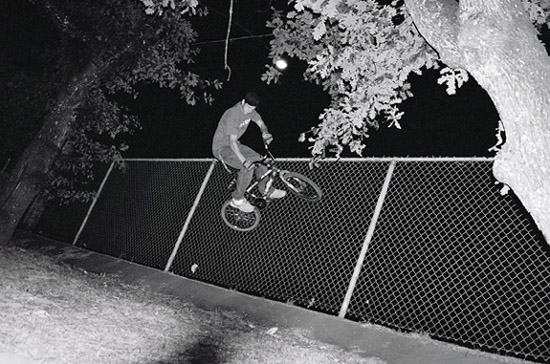 riding a bike on a fence