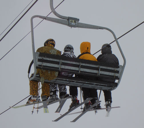 They wear matching capes, and their skis are painted to match their outfits